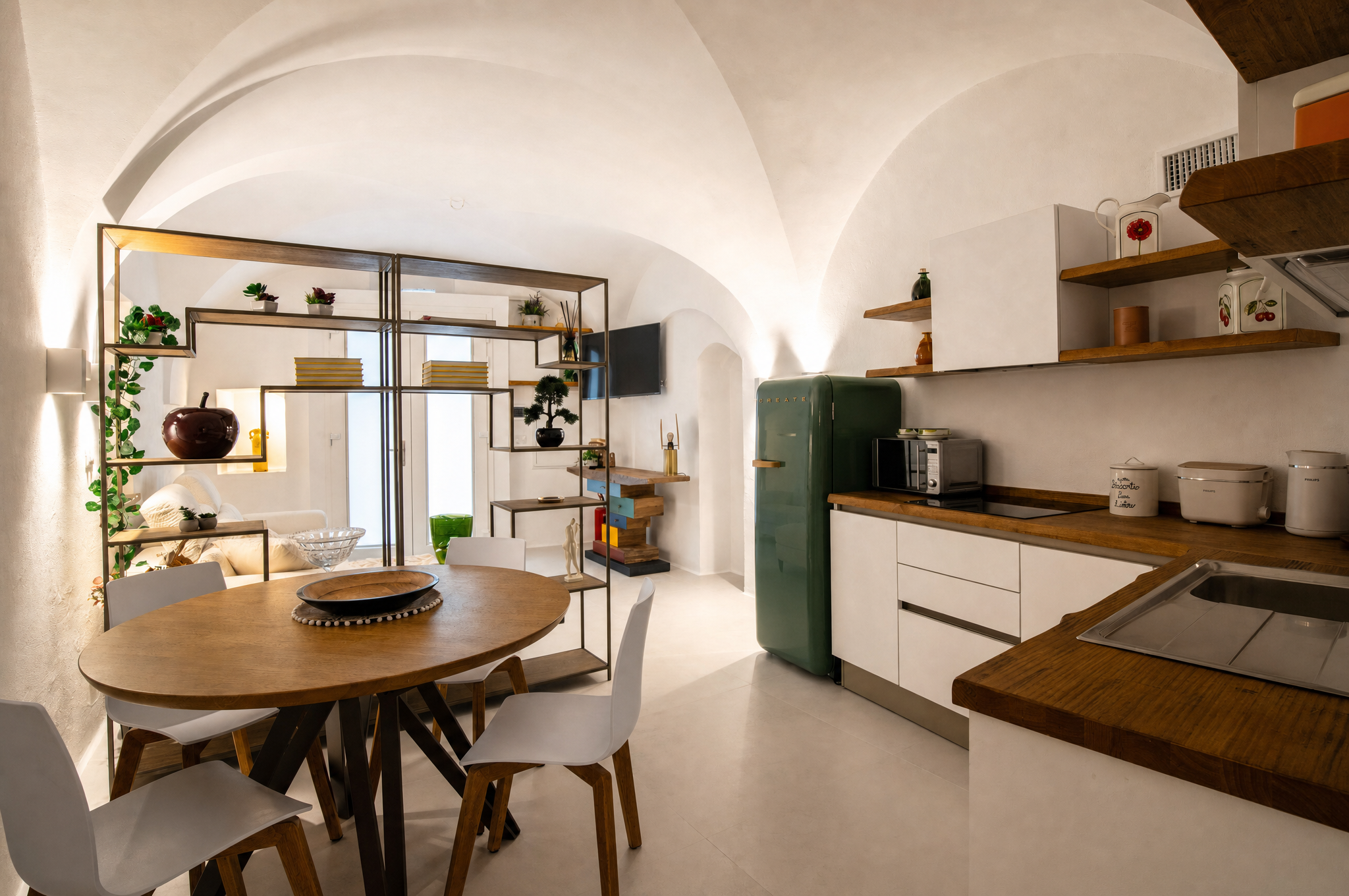 Cucina attrezzata e tavolo da pranzo sotto le volte a stella di Dimora Carucci
