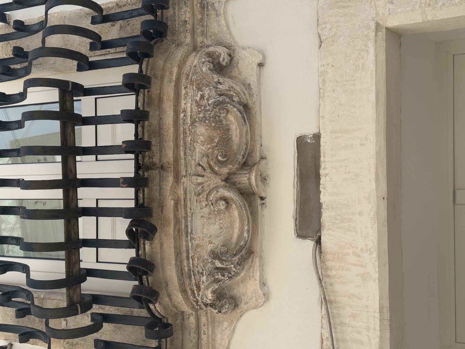 Dettaglio della mensola in pietra scolpita e del ferro battuto del balcone settecentesco