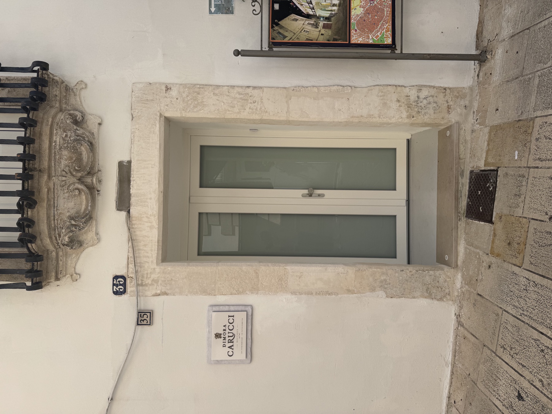 L’ingresso di Dimora Carucci al civico 35, con la targa in pietra e la mensola barocca del balcone